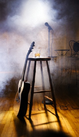 Acoustic guitar leaning against stool in nightclub
