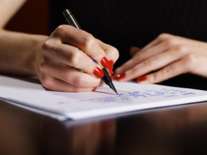 Woman Writing on Notepad