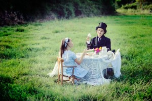 Two girls having tea in a field in France, acting out Alice in Wonderland