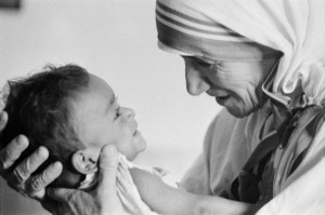 1974, Calcutta, Bengal, India --- Mother Teresa with a child from the orphanage she operates in Calcutta. Mother Teresa (Agnes Gonxha Boyaxihu), the Roman Catholic-Albanian nun revered as India's "Saint of the Slums," was awarded the 1979 Nobel Peace Prize. --- Image by © Nik Wheeler/Sygma/Corbis